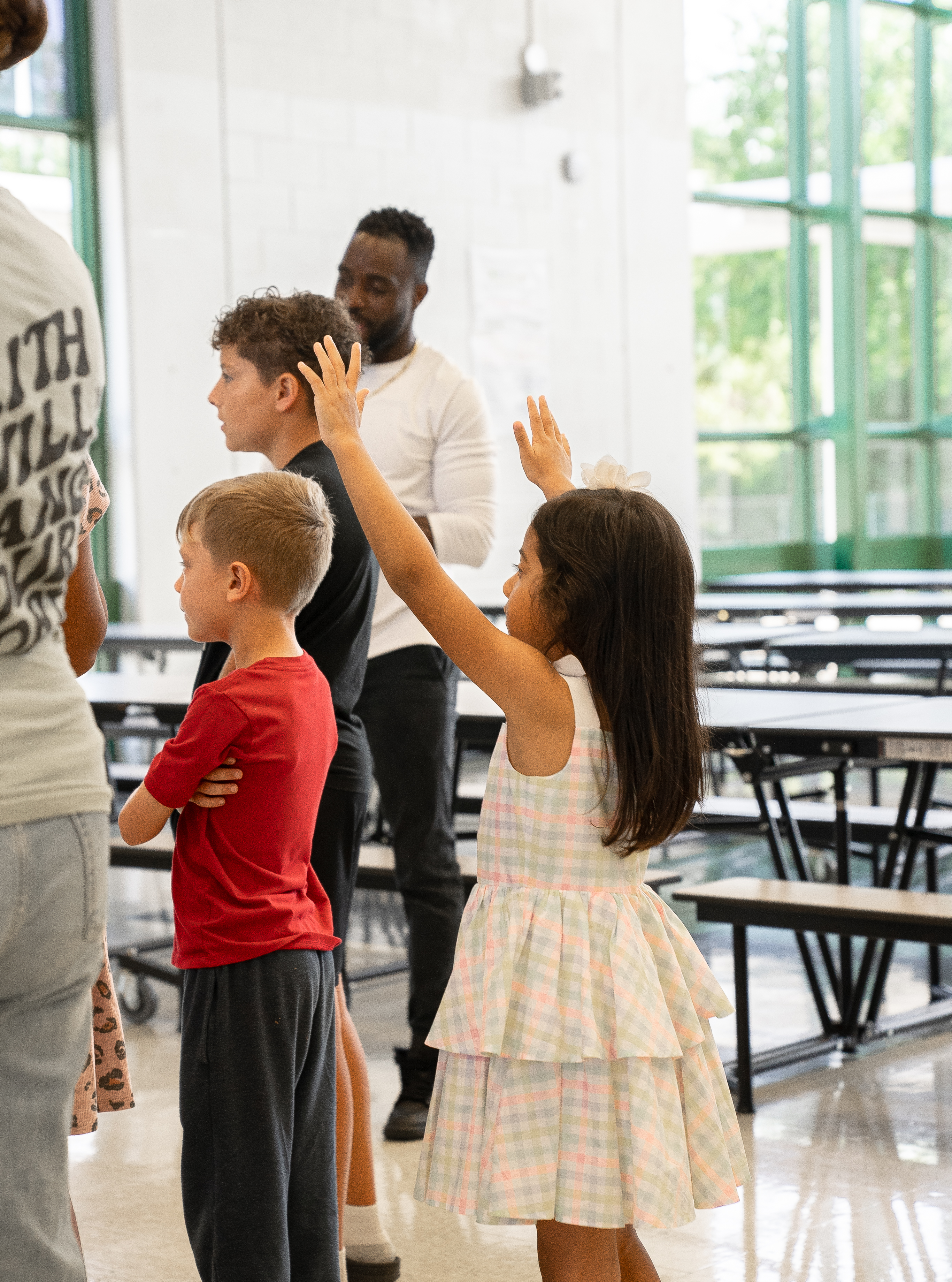 Kids with hands raised in worship at Legacy Kids