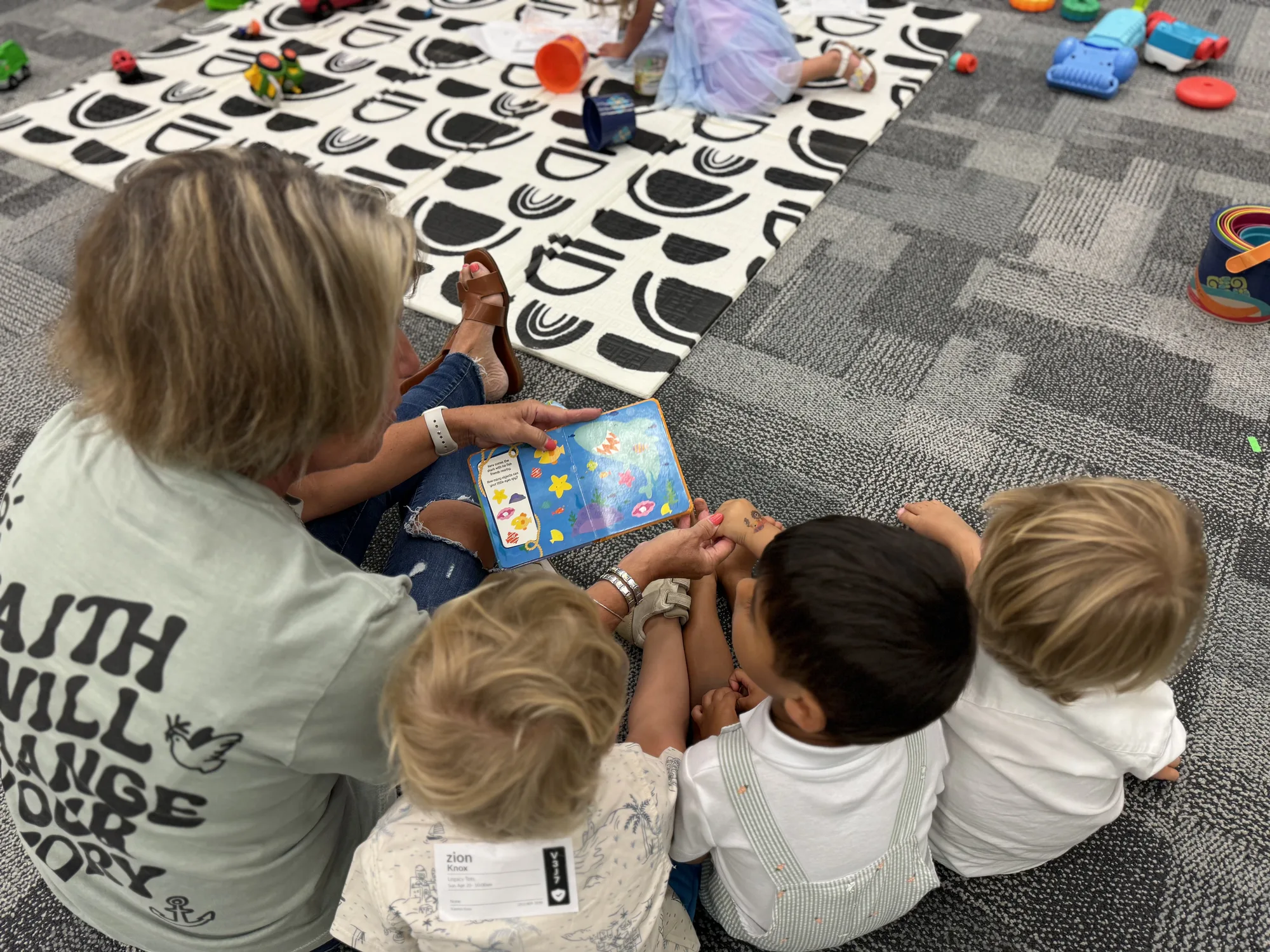 Volunteer reading to toddlers at Legacy Kids