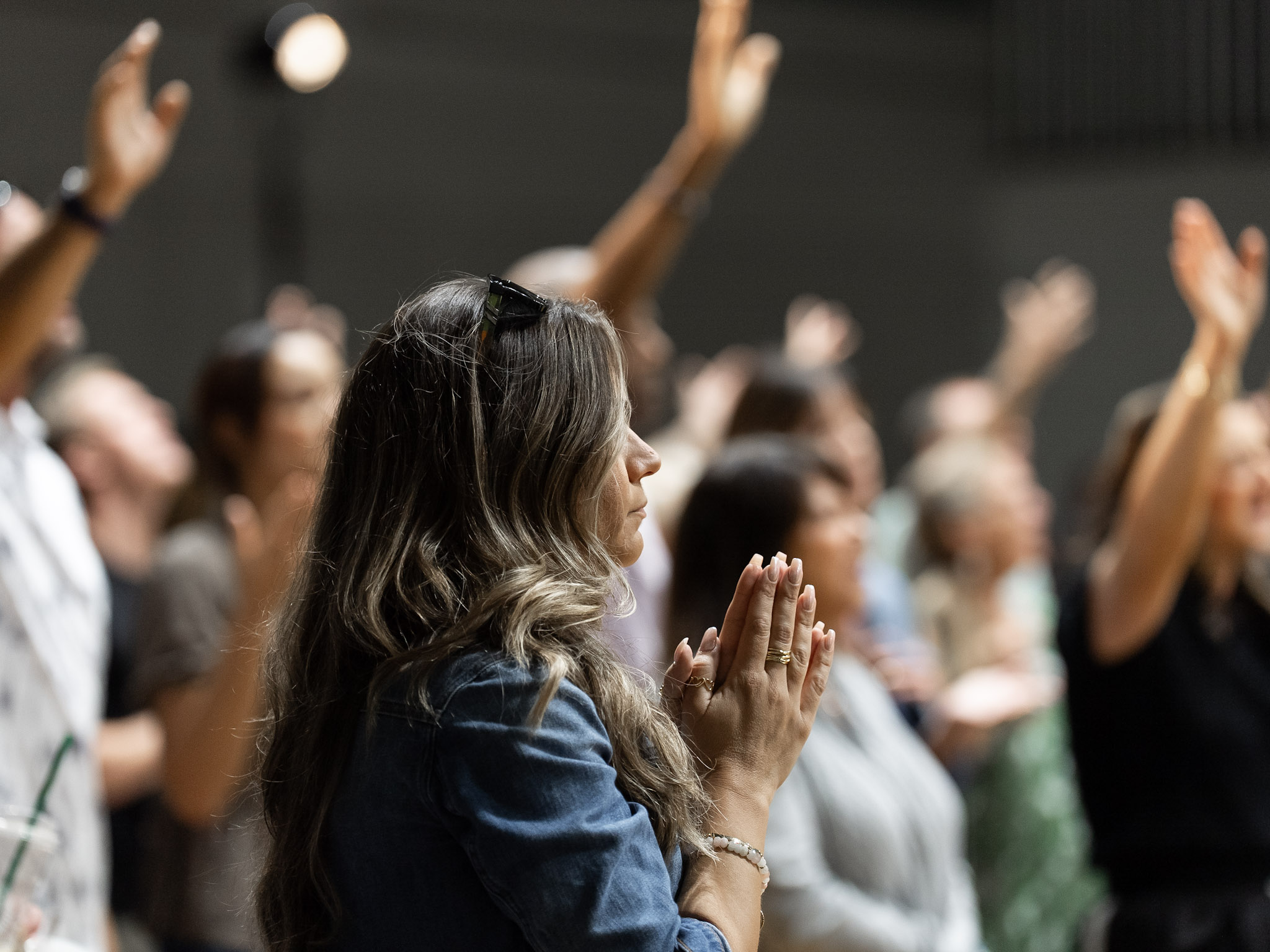 Woman praying during worship at Legacy Church